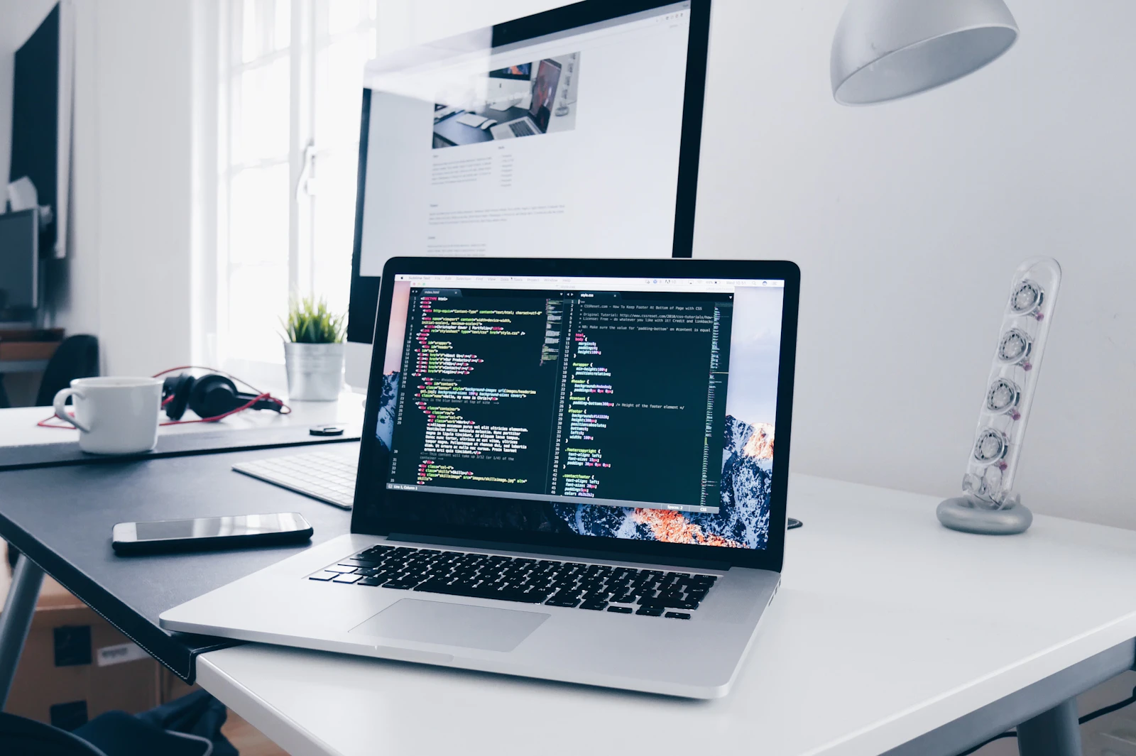 Web developer working at a laptop with code on screen
